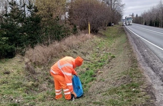 Pracownik GDDKiA zbierający śmieci wyrzucone przy drodze krajowej - woj. kujawsko-pomorskie