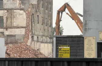 Trwa wyburzanie zabytkowego młyna przy ul. Słowackiego w Piotrkowie Trybunalskim. Zamknięty jest przejazd a mieszkańcy obserwują prace z kładki nad torami